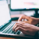 A person sitting at a desk viewed from above.