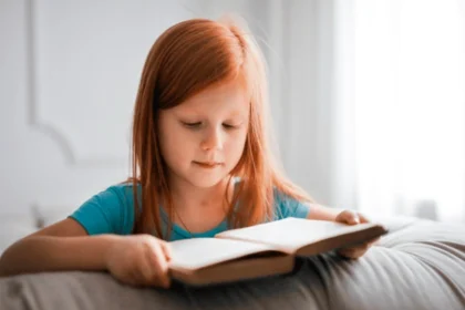 Girl in Blue T shirt Reading Book